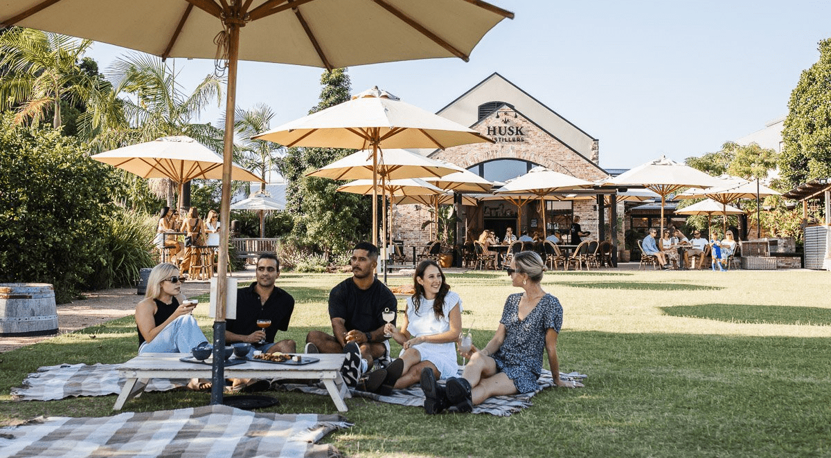 group of friends on lawn at husk farm distillery