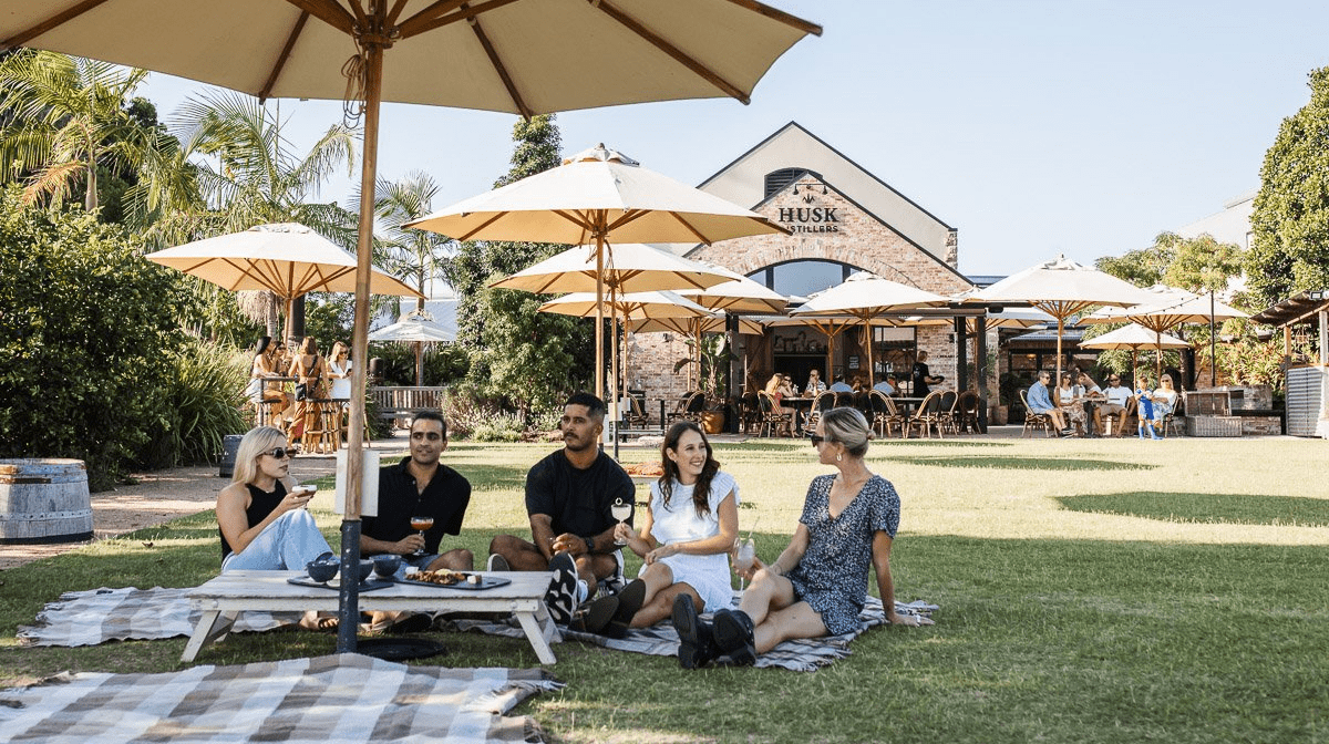 group of friends on lawn at husk farm distillery