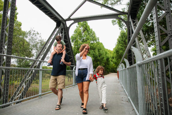 Family walking under Dunbible Bridge on the Northern River Rail Trail