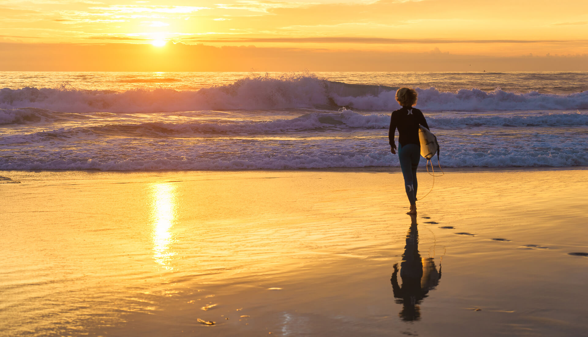 A mesmerising moment as a boy walks towards the ocean during the sunset, creating a captivating scene in The Tweed