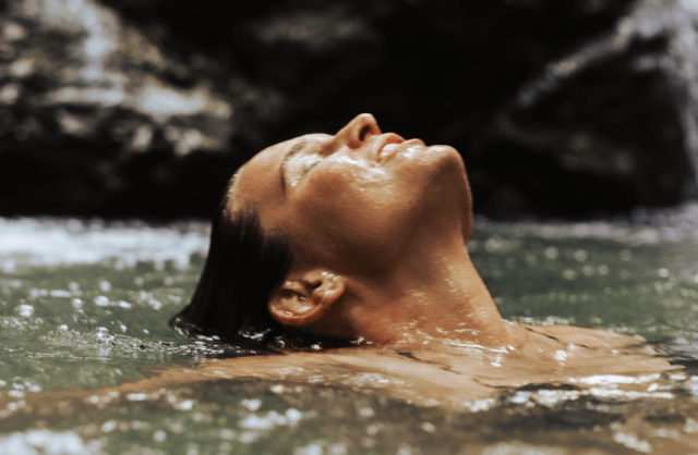 girl recharg8ing in fresh spring water on a tweed wellness experience