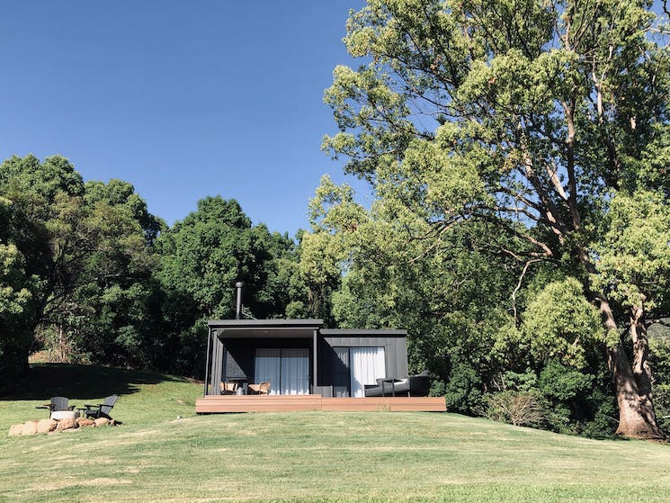 Modern black cabin on top of hill.