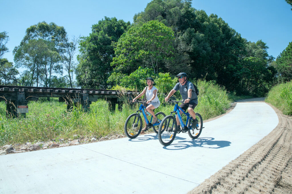 couples rides bikes on rail trail