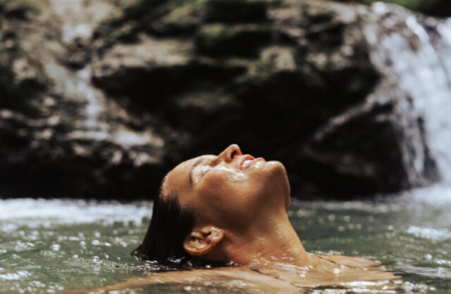 girl floating in fresh water spring at crystal creek rainforest retreat