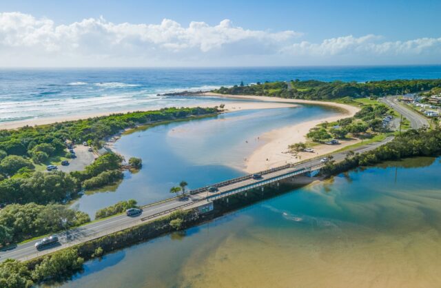 Aerial view of Cudgera Creek with cars crossing bridge