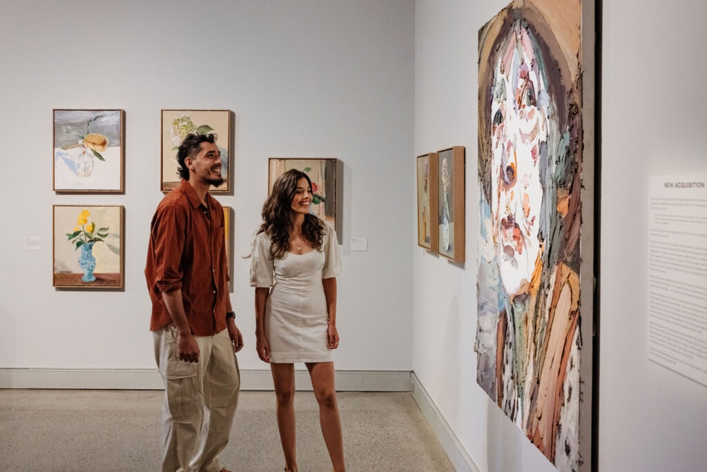 Young couple view Ben Quilty's Margaret Olley Portrait at Tweed Regional Gallery