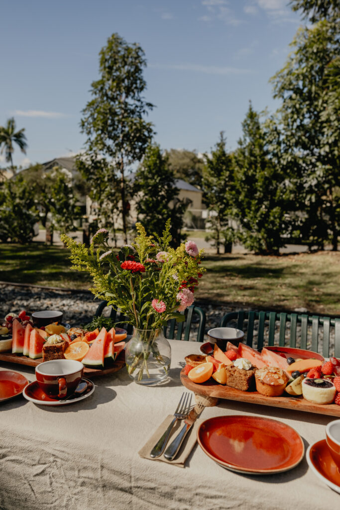 long table of fruit and pastries in outdoor setting