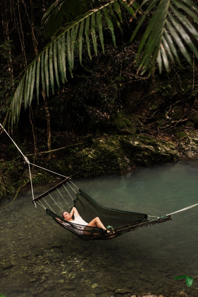 girl relaxing in hammock above creek in national park