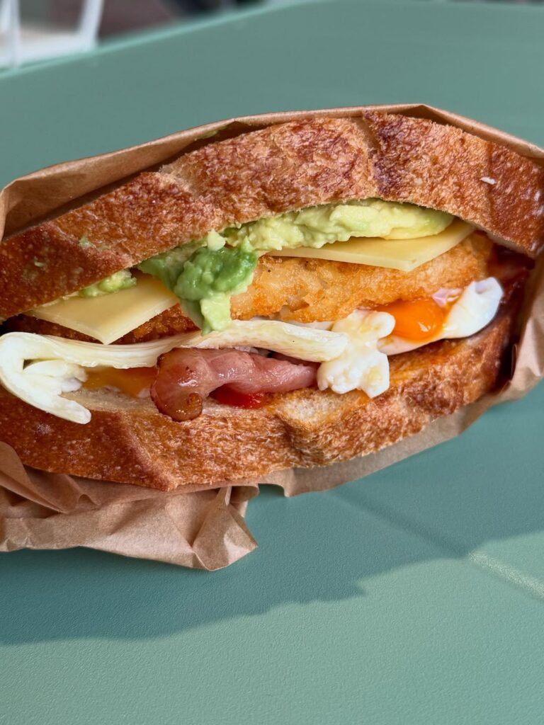 sip n bite bakehouse breakfast sandwhich with egg, bacon and avocado