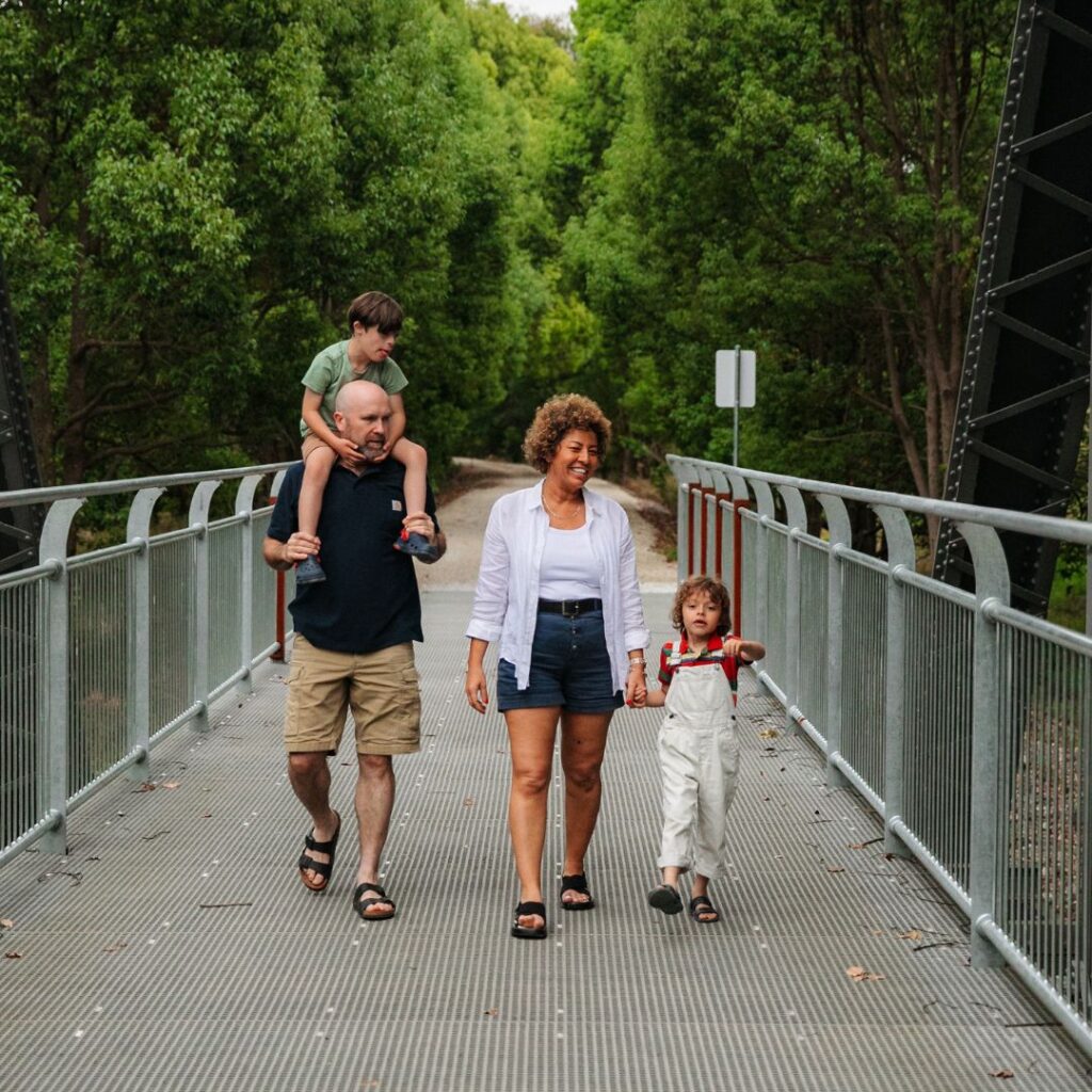Family walking across dunbible bridge on the northern rivers rail trail
