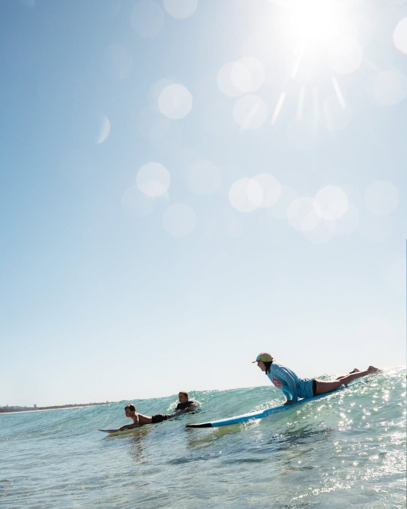 girls catching a wave with salty girls surf school