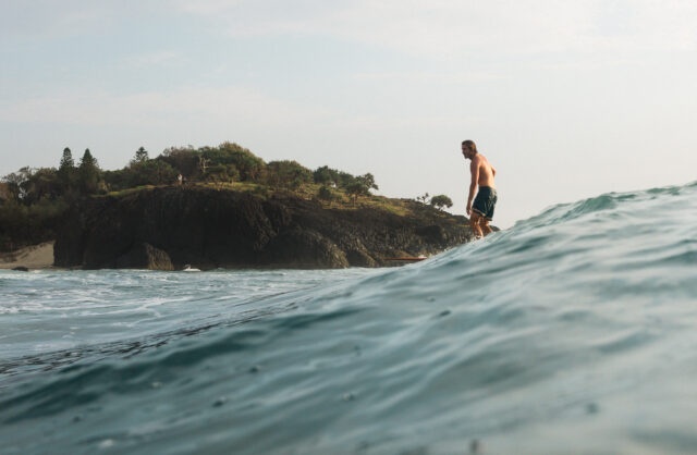 Surfer rides wave at Dreamtime Beach, FIngal Head