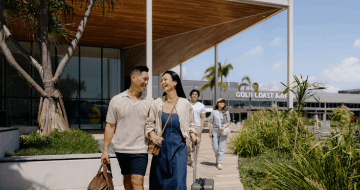 couple arrive with suitcases in hand at gold coast airport