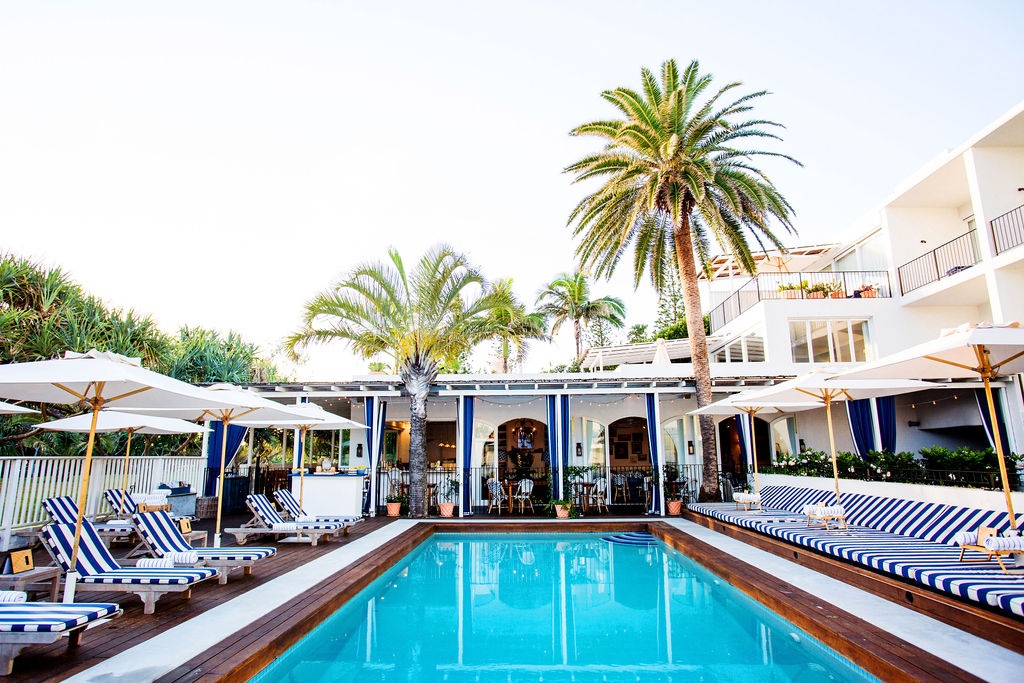 boutirque coastal accommodation with pool and striped umbrellas