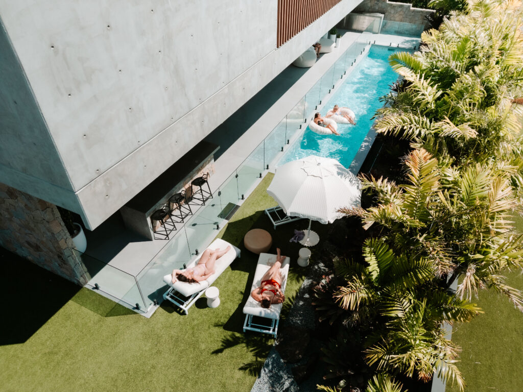 girls lounge by pool at modern group accommodation